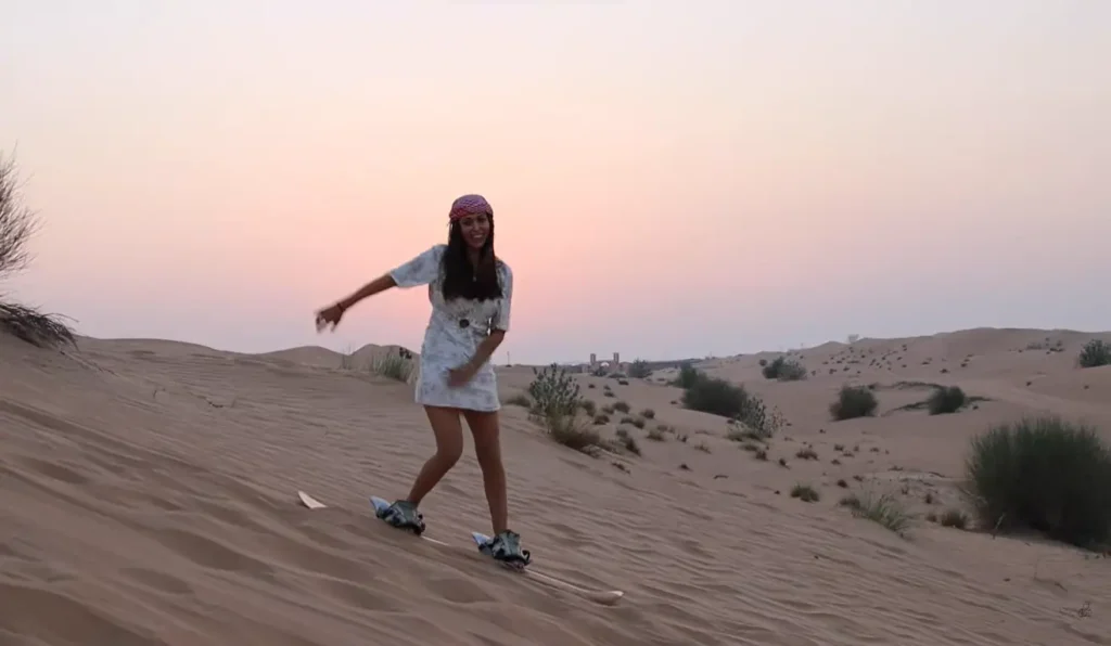 girl enjoying sandboarding on desert safari