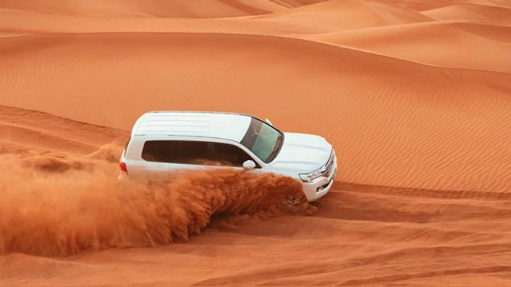 4x4 vehicle performing dune bashing in Red Dunes Desert Safari Dubai with Quad Biking – thrilling desert adventure